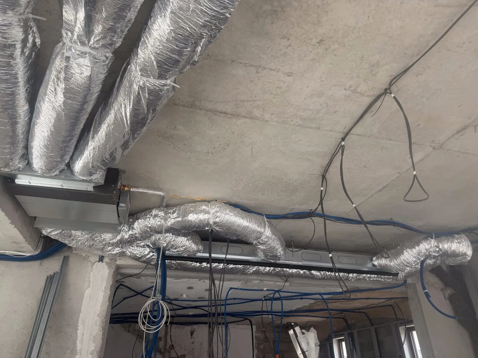 Caisson de distribution et gaines isolées d'une climatisation gainable raccordés au plafond par CMVR